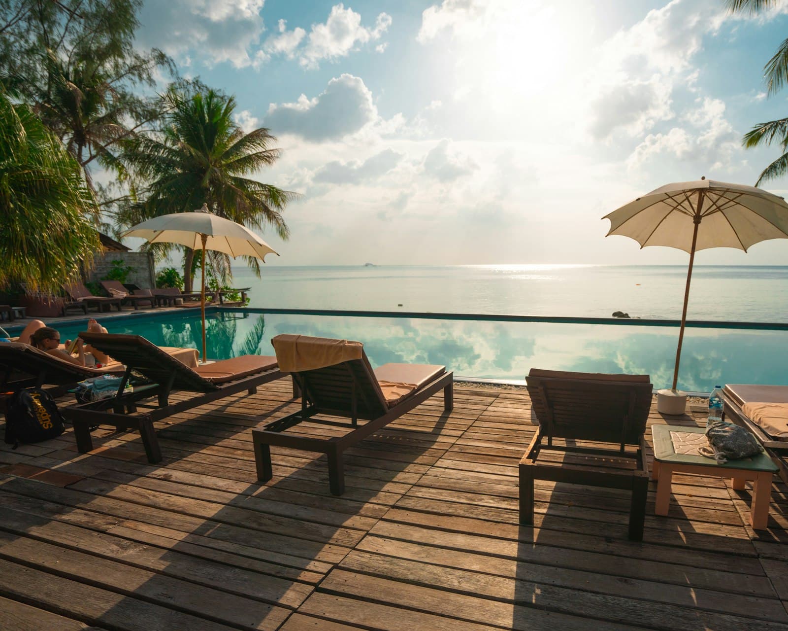 An infinity pool and empty loungers looking straight out to sea