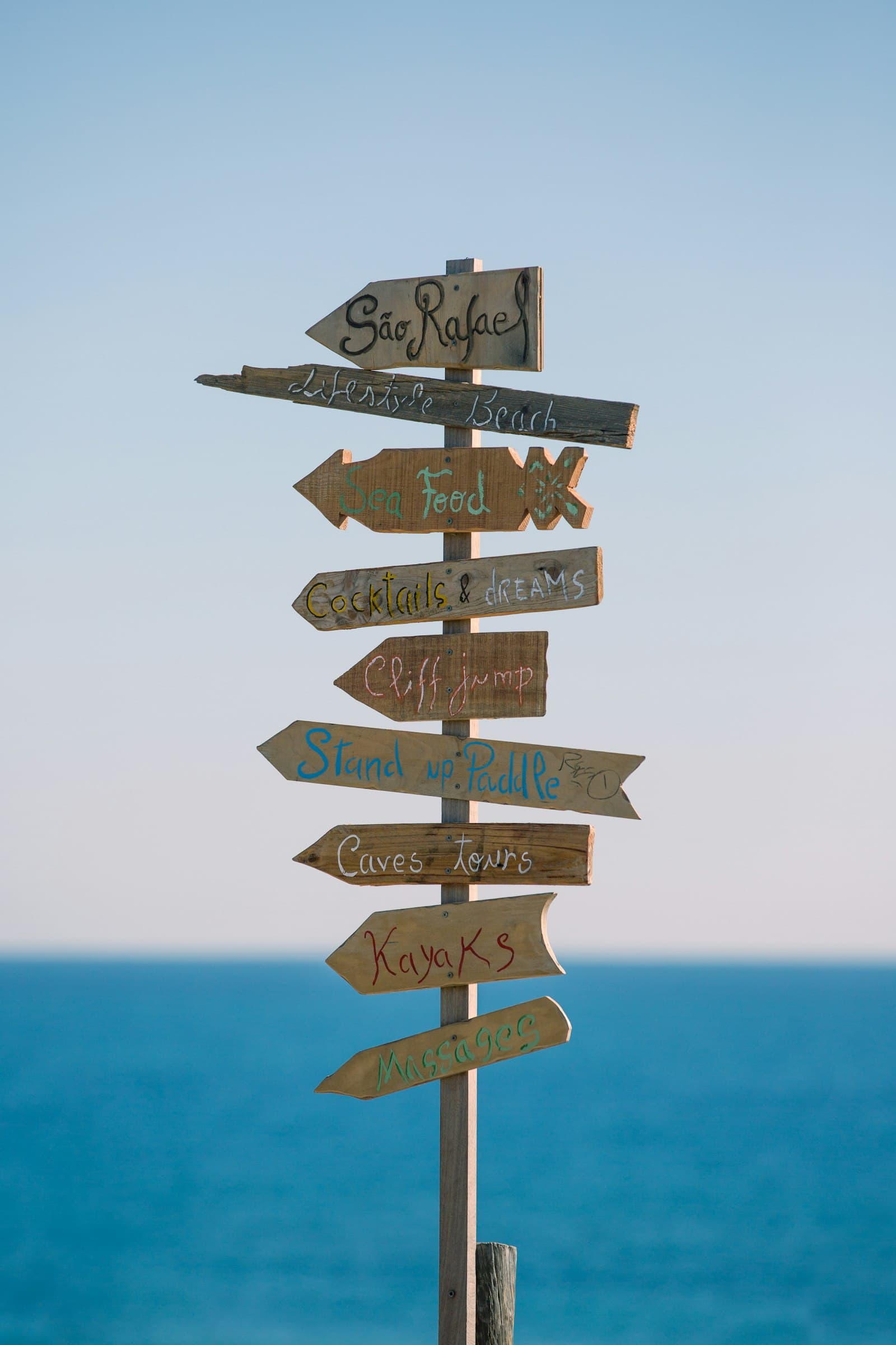 A weathered wooden signpost pointing in several directions at once