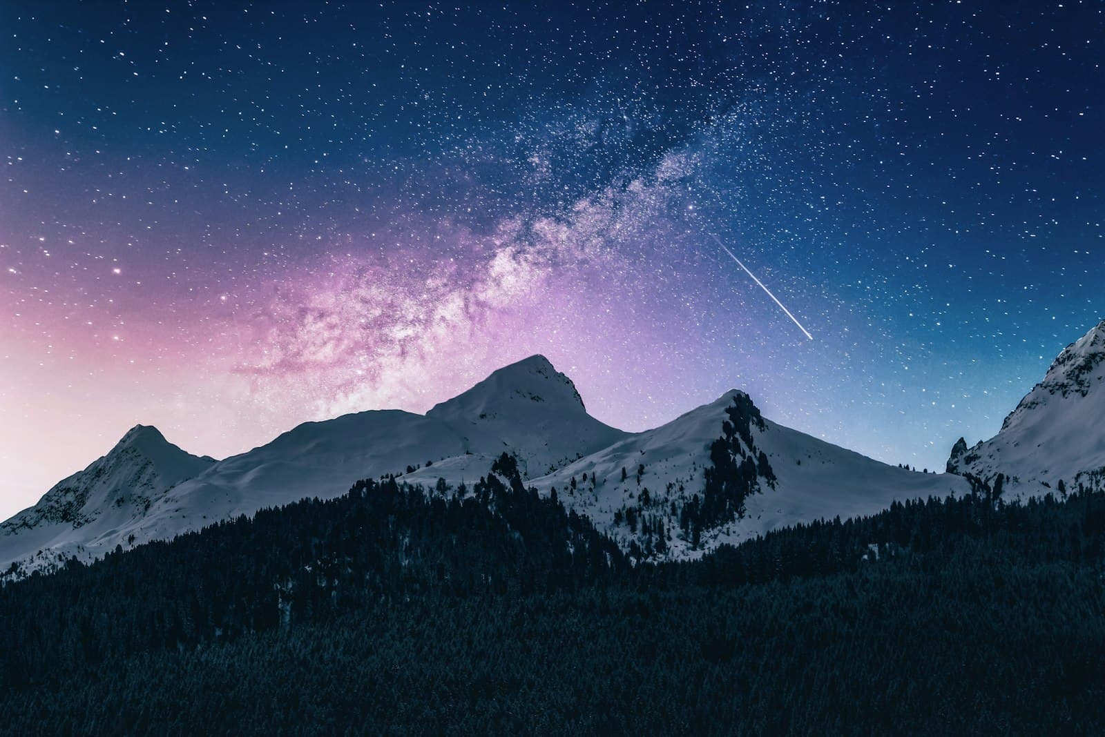 The Milky Way arcing over a dark mountain ridge line
